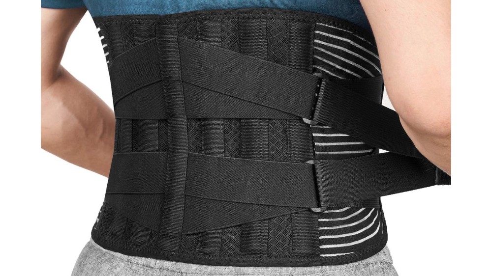 A person wearing a black back support belt that has two straps on each side.